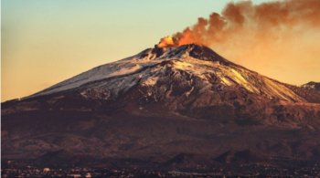 Вулкан Этна с дымом на рассвете и город Катания, Сицилия